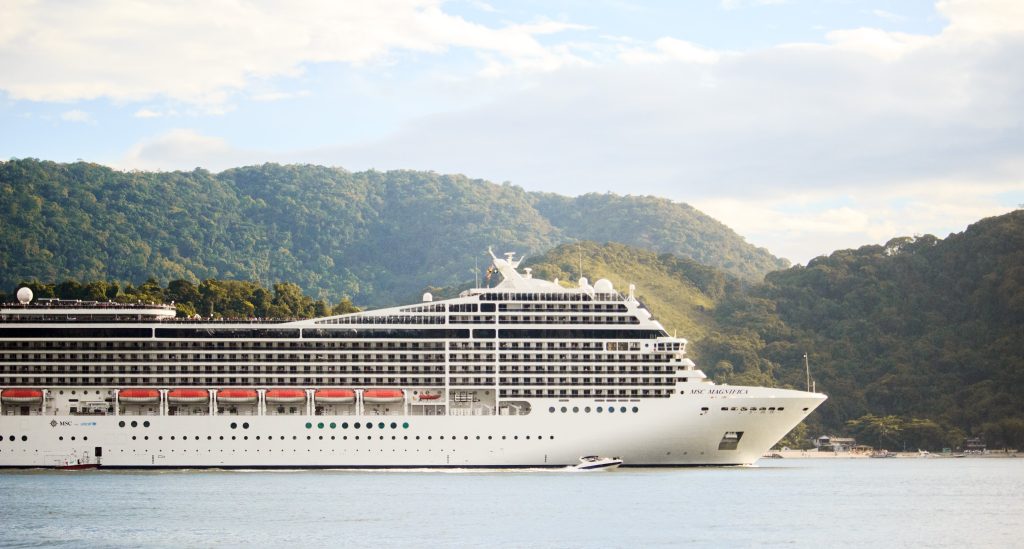 Cruise ship against the backdrop of rolling green hills