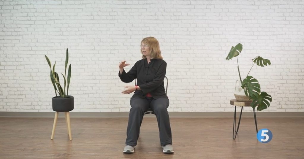 Seated Tai Chi exercise for seniors showing a slow, gentle movement for balance and mobility.