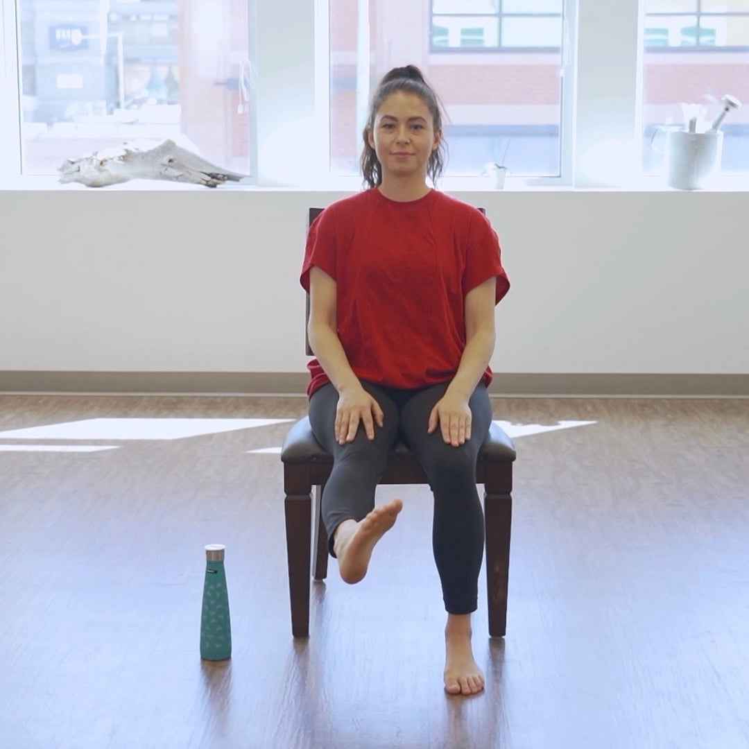 Instructor demonstrating a chair-assisted heel-to-toe walking exercise at home to improve balance, mobility, coordination, and fall prevention for older adults.