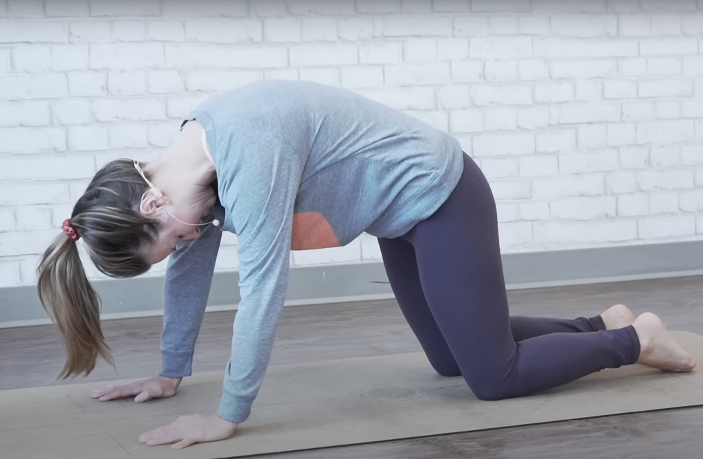 Demonstrating the cat-cow bed exercise - ending position