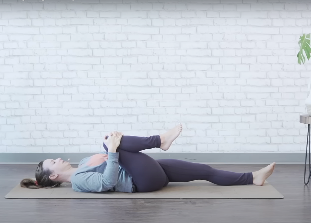 Demonstrating the single knee-to-chest bed exercise - starting position
