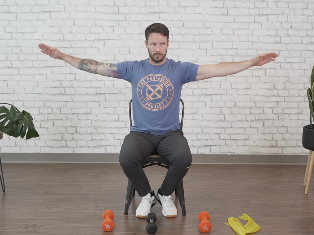 Fitness instructor demonstrates for seniors the arm-circling motion during seated arm circles.