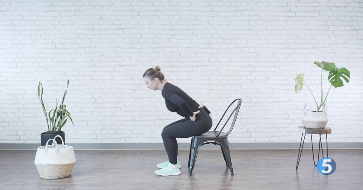 instructor performing chair assisted excercise