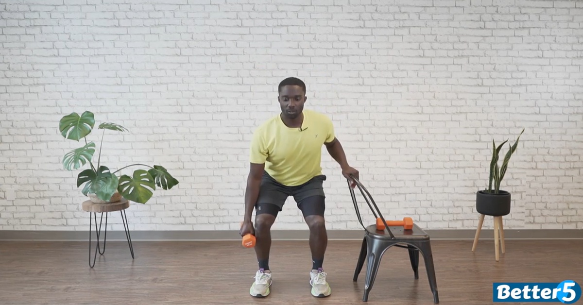 instructor demonstrating chair assisted dumbbell excercise for seniors