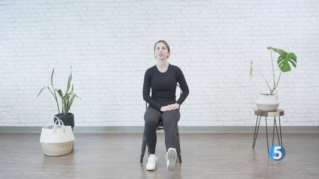 female instructor demonstrating a seated calf raise exercise for seniors with arthritis 