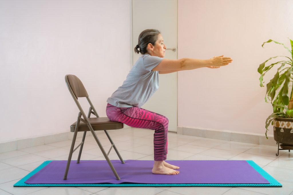 Senior woman practicing chair yoga to lose weight