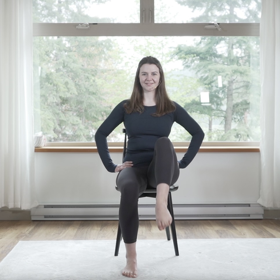 An instructor lifts her knee while seated, demonstrating one of the simplest seated exercise for seniors.