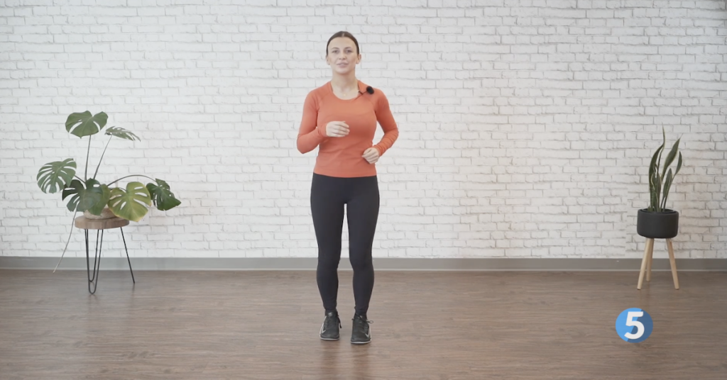 Instructor marching in place during an indoor walking exercise routine for older adults