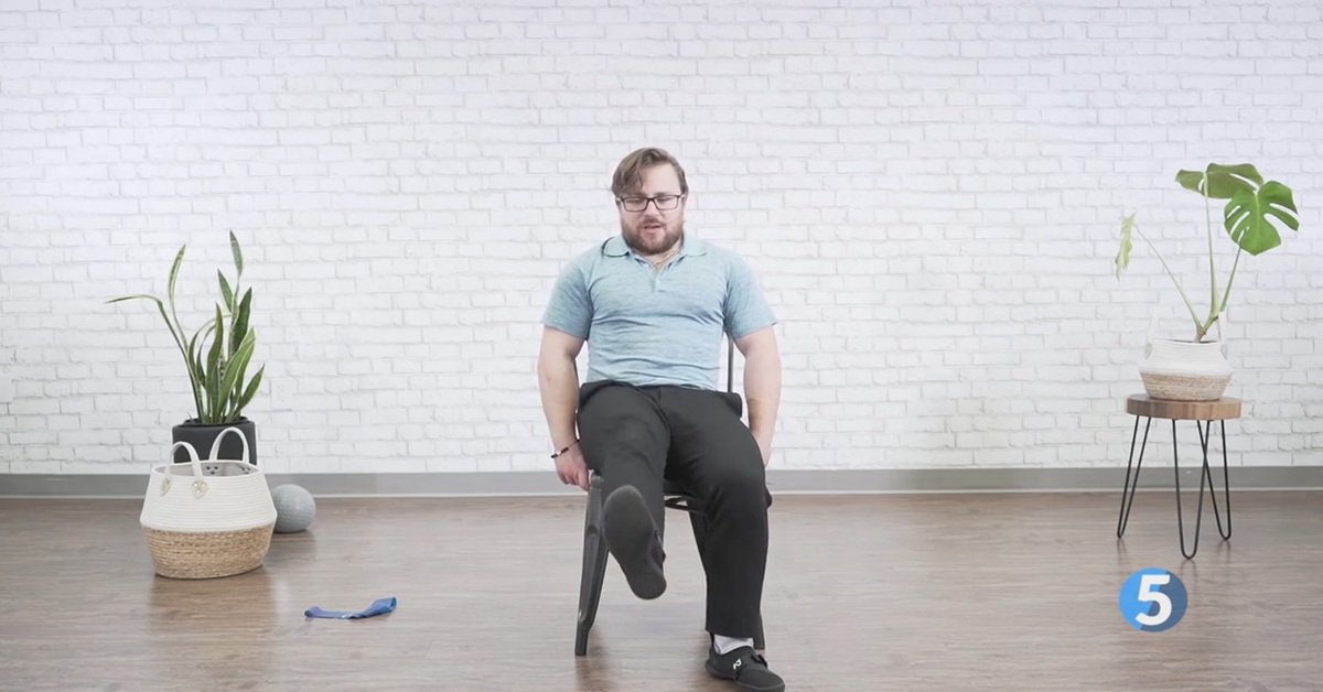 instructor performing safe seated knee excercise for seniors