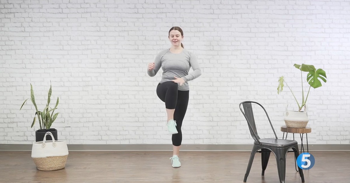 instructor performing standing leg excercise for seniors