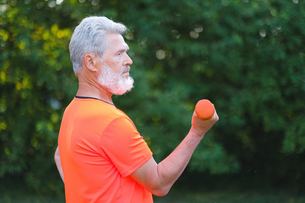 Senior man lifts weights after open heart surgery