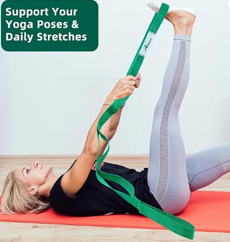 Elderly lady stretches her limb with a green yoga strap, a piece of must-have equipment for at-home senior workouts