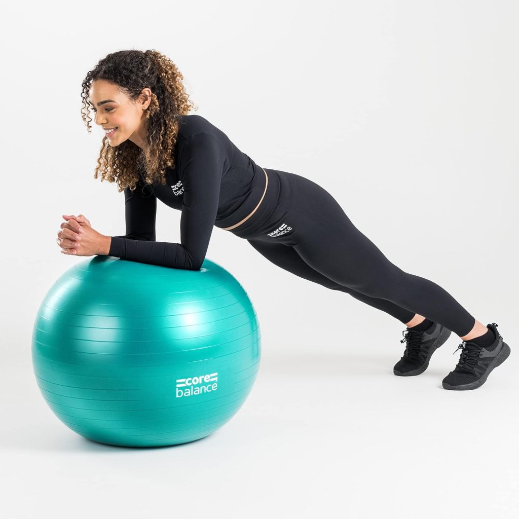 A smiling lady in all-black fit wear leans on a stability ball, which is a piece of must-have equipment for at-home senior workouts