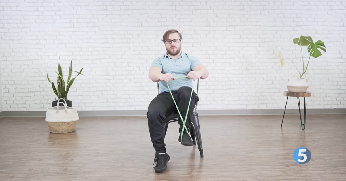 instructor doing resistance band knee strength excercise