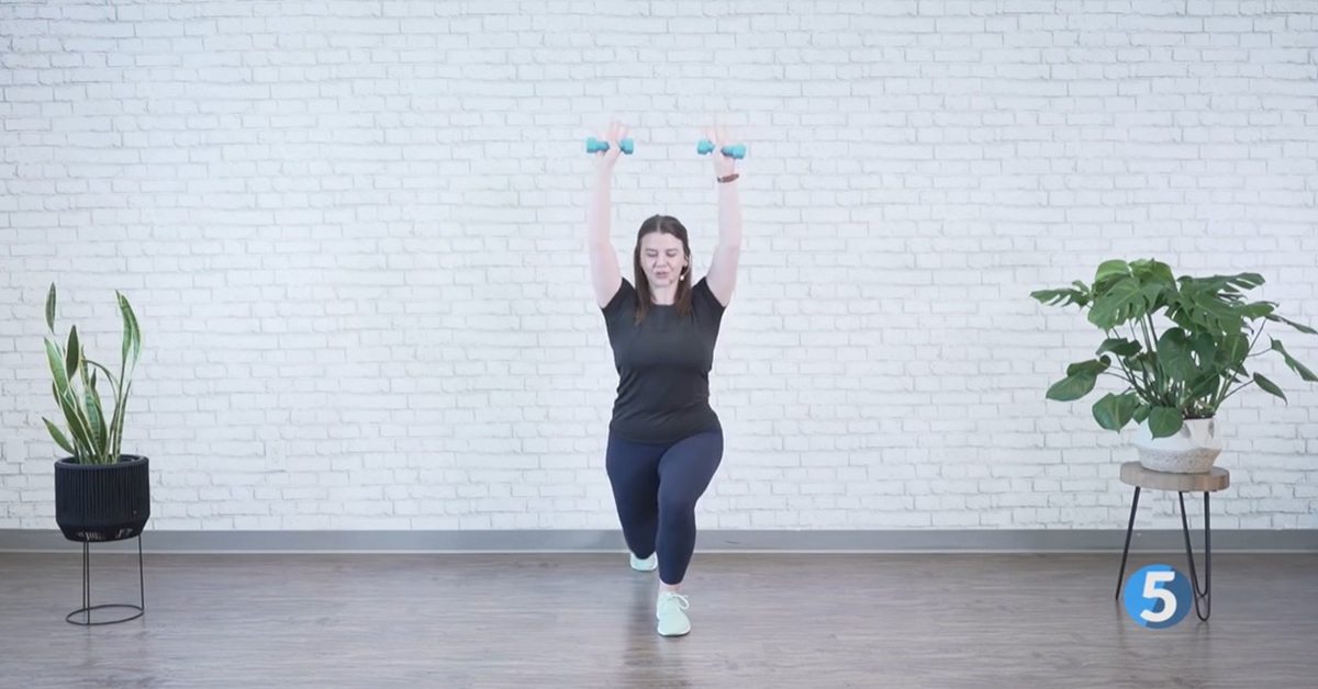 instructor performing overhead strength excercise