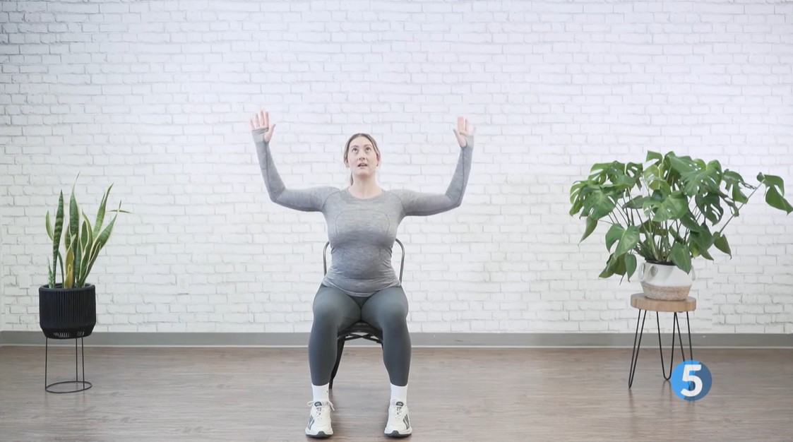 instructor doing shoulder arm stretch excercise for seniors