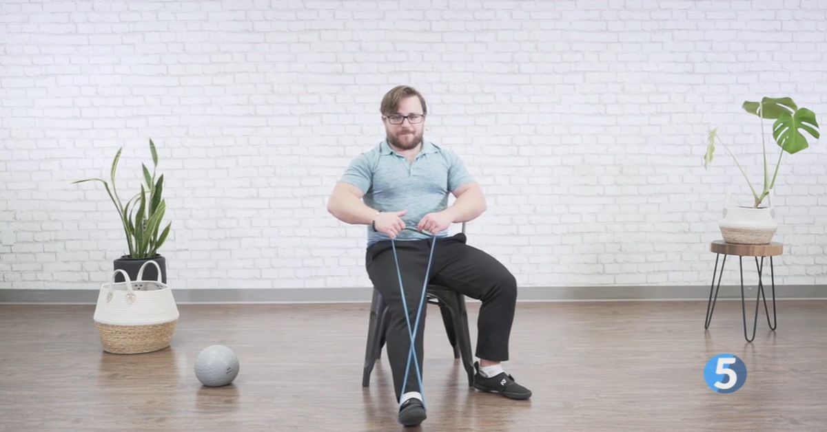 instructor doing seated leg strength excercise
