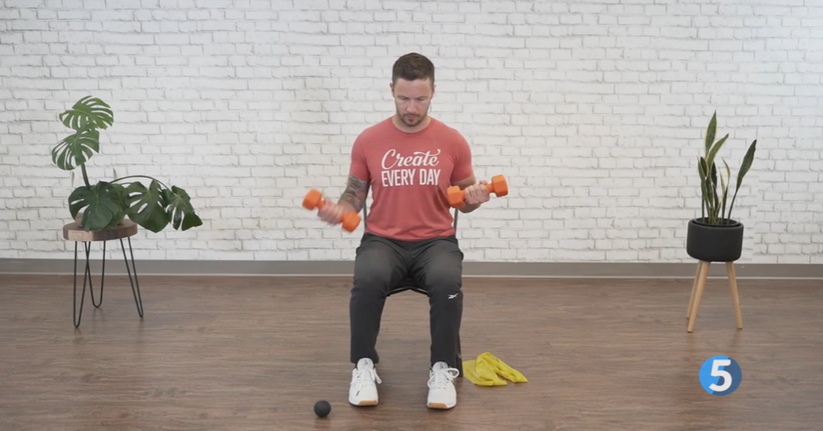 instructor doing seated arm strength excercise