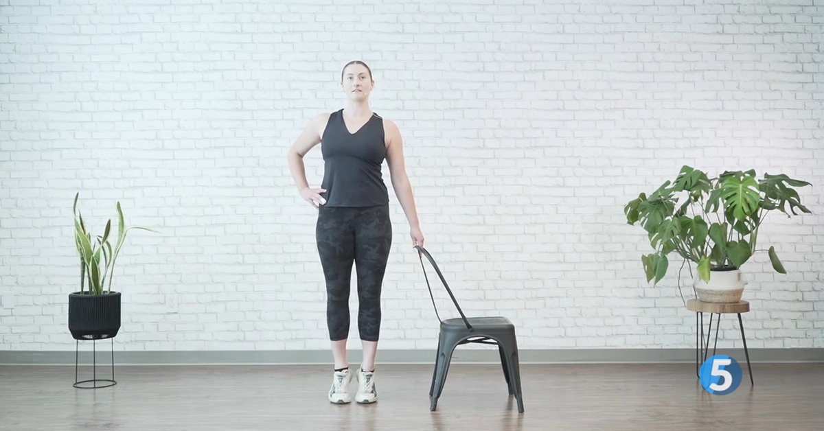 instructor demonstrating chair assisted calf raise