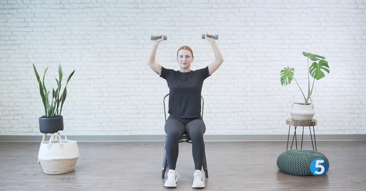 instructor demonstrating seated overhead lift